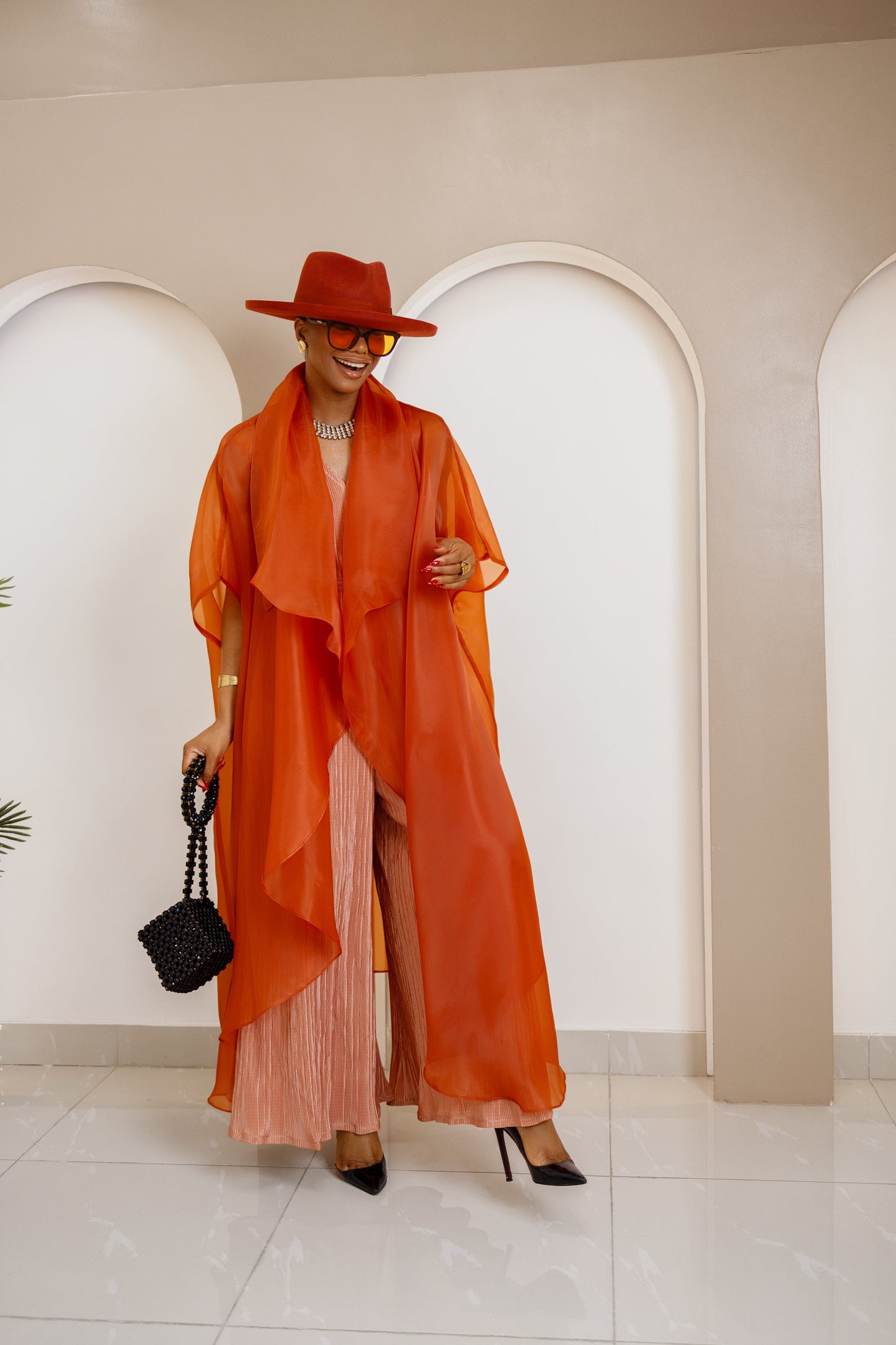Saeeda Set in Rust Duo-Toned, featuring a sheer rust organza kimono over a pleated jumpsuit.