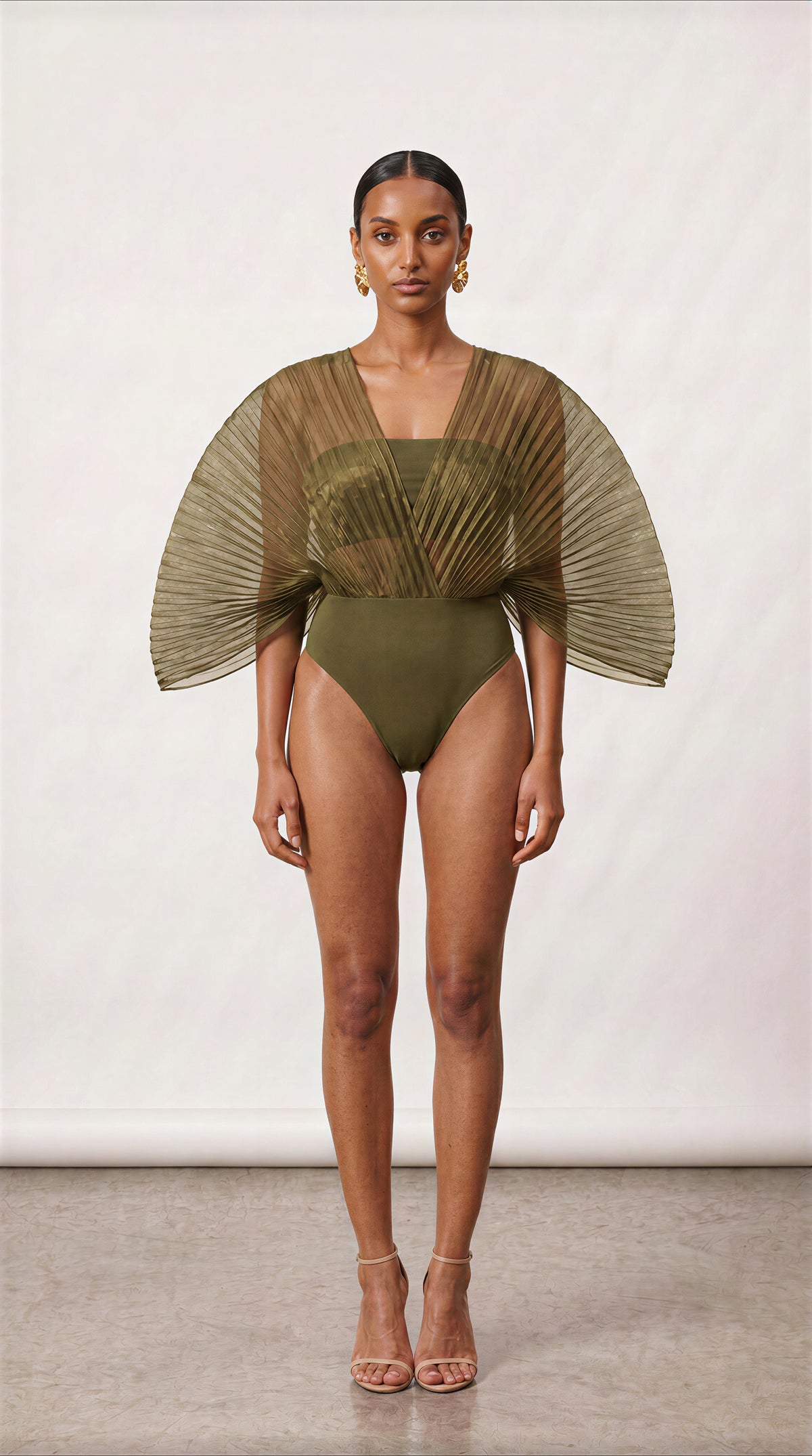 INPUTS: PRESERVE OUTFIT SILHOUETTE, DRAPE & BACKDROP FROM Master_Bodysuit_Render.png | RECOLOR OUTFIT TO OLIVE GREEN FROM The New Black (60).jpg | SWAP HEAD, FACE & SKIN TONE 100% TO Model_Reference_2.jpg]

Model Profile (MODEL REFERENCE 2 LOCK):

Replace the model entirely with Model Reference 2 from Model_Reference_2.jpg.

Positioned facing directly forward. Lock onto her exact facial features, warm-bronze skin tone, and natural matte skin texture (zero oily reflections, zero specular face glare).

Hair s